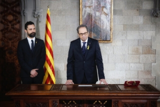 El president de la Generalitat, Quim Torra, i del president del Parlament , Roger Torrent, darrera una taula amb el medalló que simbolitza la Presidència de la Generalitat