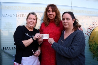 Tres dones subjectant el dècim d&#039;un dels cinquens premis de la rifa de Nadal davant l&#039;administració número 19 de Tarragona