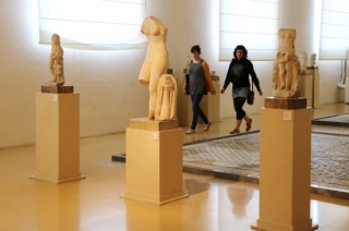 Tres figures del MNAT i, entre mig, dues visitants en la Nit dels Museus del 2017