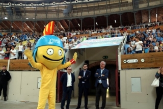 El Tarracus, la mascota dels Jocs, saludant als més de 2.000 escolars a la Tarraco Arena Plaça, durant la presentació de la cançó oficial dels Jocs, amb l&#039;exalcalde Ballesteros al costat