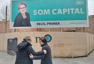 Teresa Pallarès parlant amb una ciutadana davant de la tanca publicitària &#039;Som Capital. Reus, primer&#039;