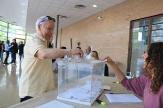 Un home votant en una de les meses constituïdes al Palau Firal de Tarragona