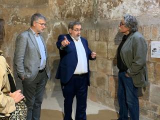 Pau Ricomà i Joan Tardà escolten les explicacions del director del Museu Bíblic durant la visita al refugi antiaeri