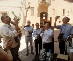 L&#039;alcalde de Barberà de la Conca, Marc Rovira, mostra a uns visitants la tradició de veure vi amb un porró de Vimbodí.