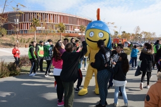 La mascota del Jocs Tarracvs, amb un grup d&#039;estudiants a l&#039;Anella Mediterrània