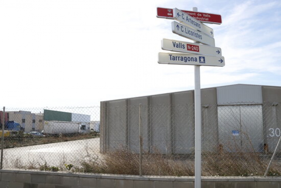 Senyals d&#039;indicació al polígon industrial de Valls, amb unes naus en venda al fons, el 28 de gener del 2021.