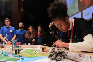 Una estudiant ajusta el robot  amb què competeix a la First Lego League