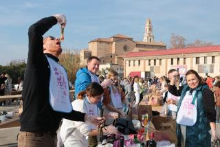 Una família de turistes menja calçots durant la 42a Gran Festa de la Calçotada de Valls