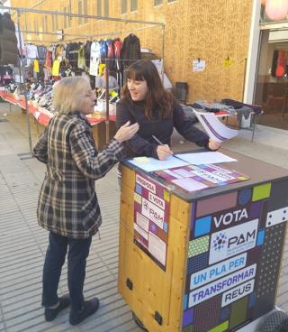 Una ciutadana participant en la votació en un dels estands físics situat al Mercat del Carrilet