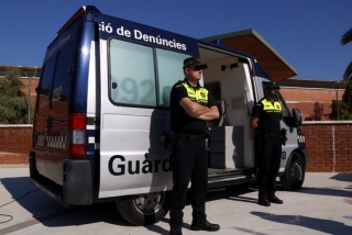 Dos agents de la Guàrdia Urbana de Tarragona al costat d&#039;una oficina mòbil de denúncies, davant el centre cívic de Torreforta