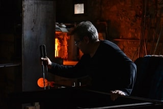 El mestre vidrier Paco Ramos fent una demostració de la tècnica del vidre bufat, al forn del Museu del Vidre de Vimbodí