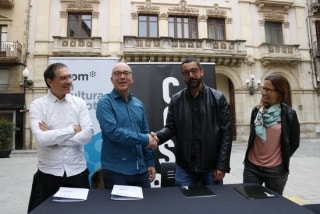 Encaixada de mans del director del grup Som, Oriol Soler, i del nou president de la CCCC, Roger Gispert, a la plaça del Blat, davant l&#039;Ajuntament, després d&#039;anunciar l&#039;acord de les retransmissions castelleres